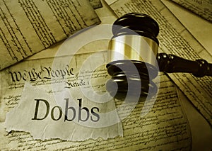 Dobbs news headline and gavel on a copy of the United States Constitution - abortion access concept