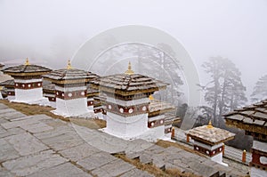 Dochu La Pass with 3-layered chortens stupas, on central hillock, along east-west road from Thimpu to Punakha, Bhutan