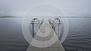 Dock with benches on foggy lake in Bemidji Minnesota