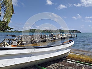 Dock at the Caribbean coast fisherman`s wharf with fishing gear. Fisherman boat side view close-up under tropical blue sky. Frenc