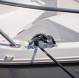Dock cleat on the side of a boat in a small marina, an element o
