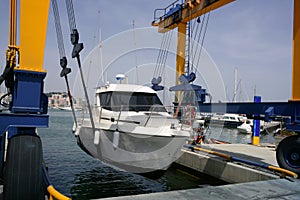Dock crane elevating a fishing boat