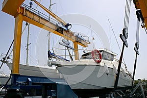 Dock crane elevating a fishing boat