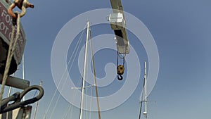 Dock crane hangs above sails of boats and yachts in Richardson Bay Marina