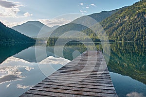 Dock leading into a beautiful mountain lake in the Austrian alps