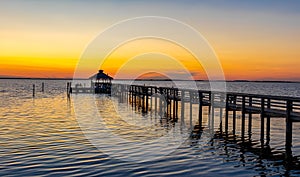 Dock leading out to a bay at sunset in the Outer Banks of North Carolina