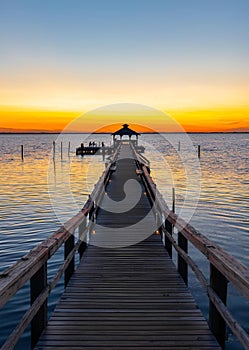 Dock leading out to a bay at sunset in the Outer Banks of North Carolina