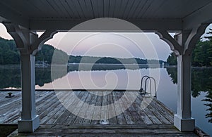 A dock looking out onto a lake at dawn.