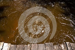 a dock in the middle of some muddy water that is brown