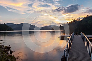 Dock on a mountain lake at sunset