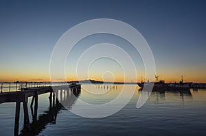 Dock with sunset in the sea and ships