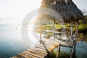 Dock during sunset with sun beam at lake Itza, El Remate, Peten, Guatemala