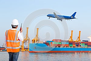 Dock worker talking on the walkie-talkie for controlling loading