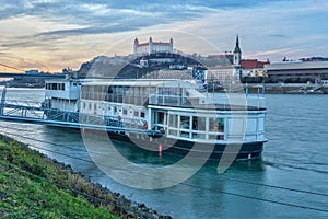 Docked ship at Danube river bank and Bratislava castle