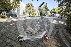 Dockless electric kick scooters from a scooter-sharing system parked on a sidewalk photo