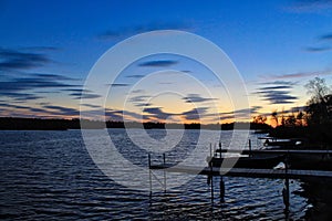 Sunset over large lake and docks jutting into water located in Hayward, Wisconsin