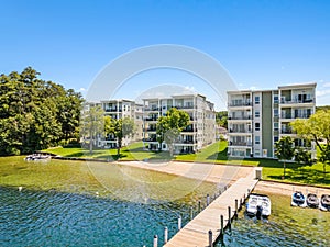 the docks of a lake with boats and apartment buildings in the background, in Lakeport New Hampshire.