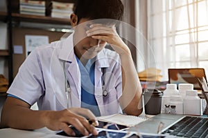 Docter eyestrain fatigued from computer work, stressed man suffer from headache bad vision sight problem sit at office table using