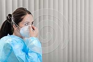 Doctor adjusting Covid-19 N95 mask in the office