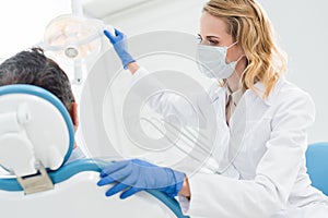 Doctor adjusting lamp in modern