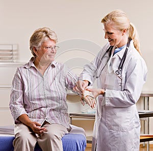 Doctor adjusting senior woman wrist splint