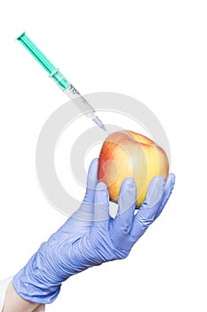 Doctor aesthetician makes beauty injections to apple on isolated background