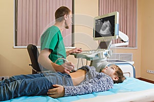 Doctor analyzing boy patient with abdomen ultrasound