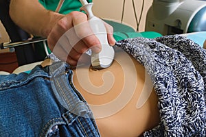 Doctor analyzing boy patient with abdomen ultrasound