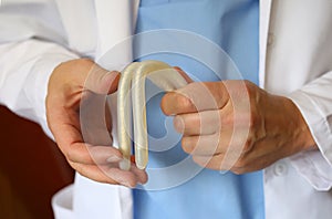 Doctor andrologist holding in his hands demonstrates the work of hydraulic penile prosthesis for falloprosthetics. Penile photo