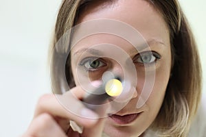 Doctor anesthesiologist resuscitator shining medical flashlight into patient eyes closeup