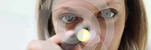 Doctor anesthesiologist resuscitator shining medical flashlight into patient eyes closeup photo