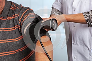 Doctor applies cuff for blood pressure measurement