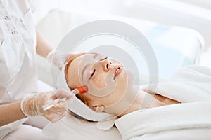 Doctor applies Hydro gel Mask on the woman before making laser treatment.