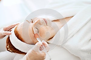 Doctor applies Hydro gel Mask on the woman before making laser treatment.