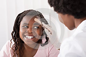 Doctor Applying Band Aid To Girl Head