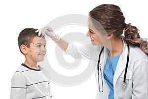 Doctor applying cream onto skin of little boy with chickenpox on background. Varicella zoster virus
