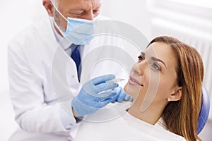 Doctor applying lip fillers to female patient