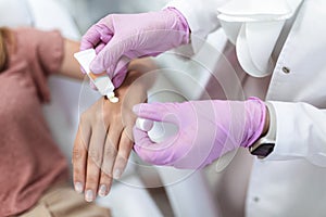 Doctor applying protective cream on patient's hands