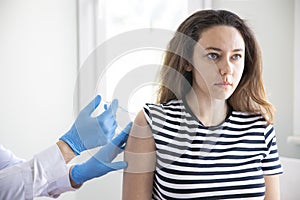 Doctor applying a vaccine on a woman`s arm