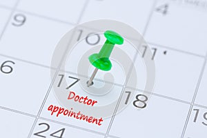 Doctor appointment on a calendar with a green push pin to remind