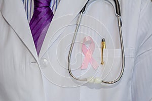 Doctor with arms crossed wearing breast cancer awareness ribbon