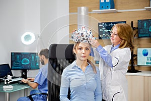 Doctor arranging brain waves scanning headset for a patient