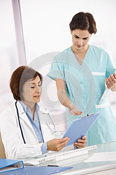 Doctor and assistant discussing work