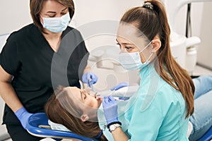 Doctor and assistant examining woman teeth with 3D dental scanner