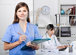 Doctor assistant standing in medical office noting prescriptions