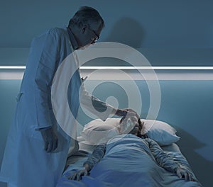 Doctor assisting a hospitalized patient at night