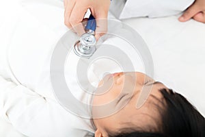 The doctor auscultated the child lying in bed