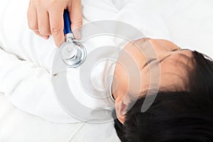 The doctor auscultated the child lying in bed