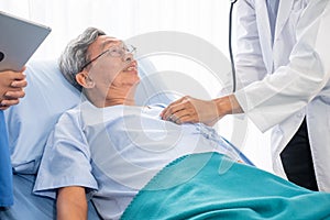 Doctor auscultating for Asian patient men by using stethoscope at the hospital room