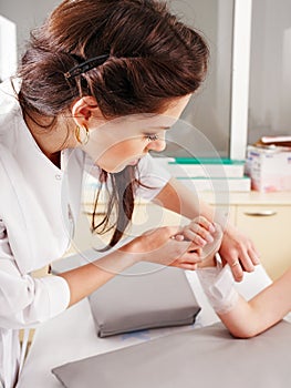 Doctor bandaging patient in hospital.